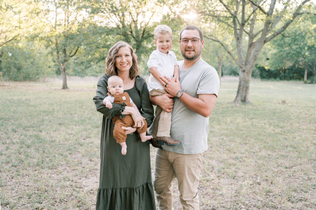 family poses for a photo in a field