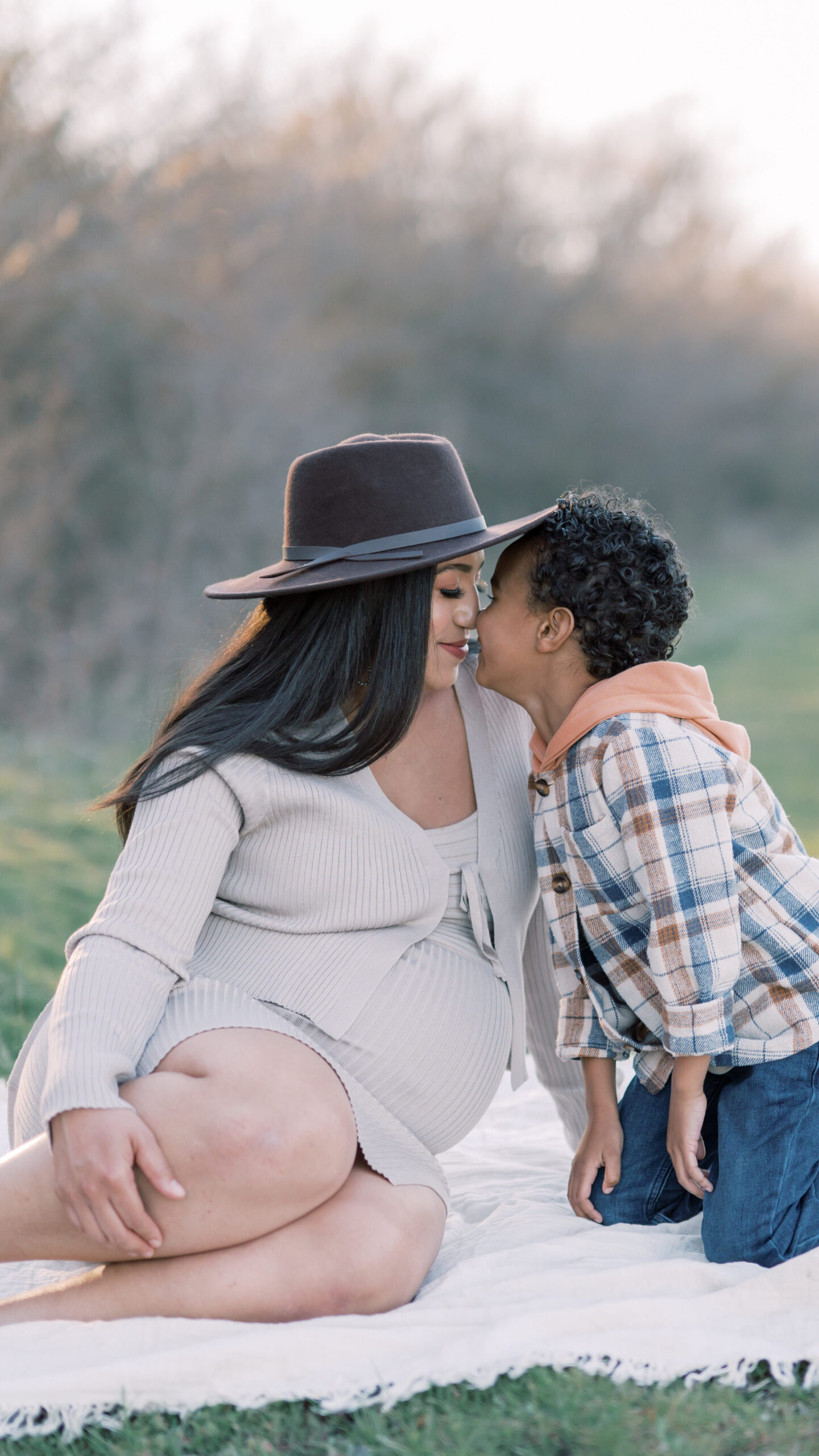maternity session photo of mom and son cuddling in fort worth park during maternity photos