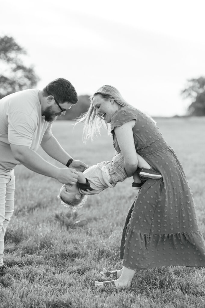 parents tickle toddler during family photo session