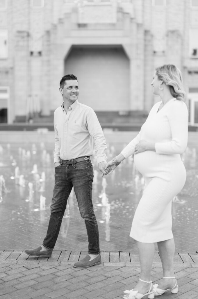 expecting parents walk together during maternity photography session in fort worth 