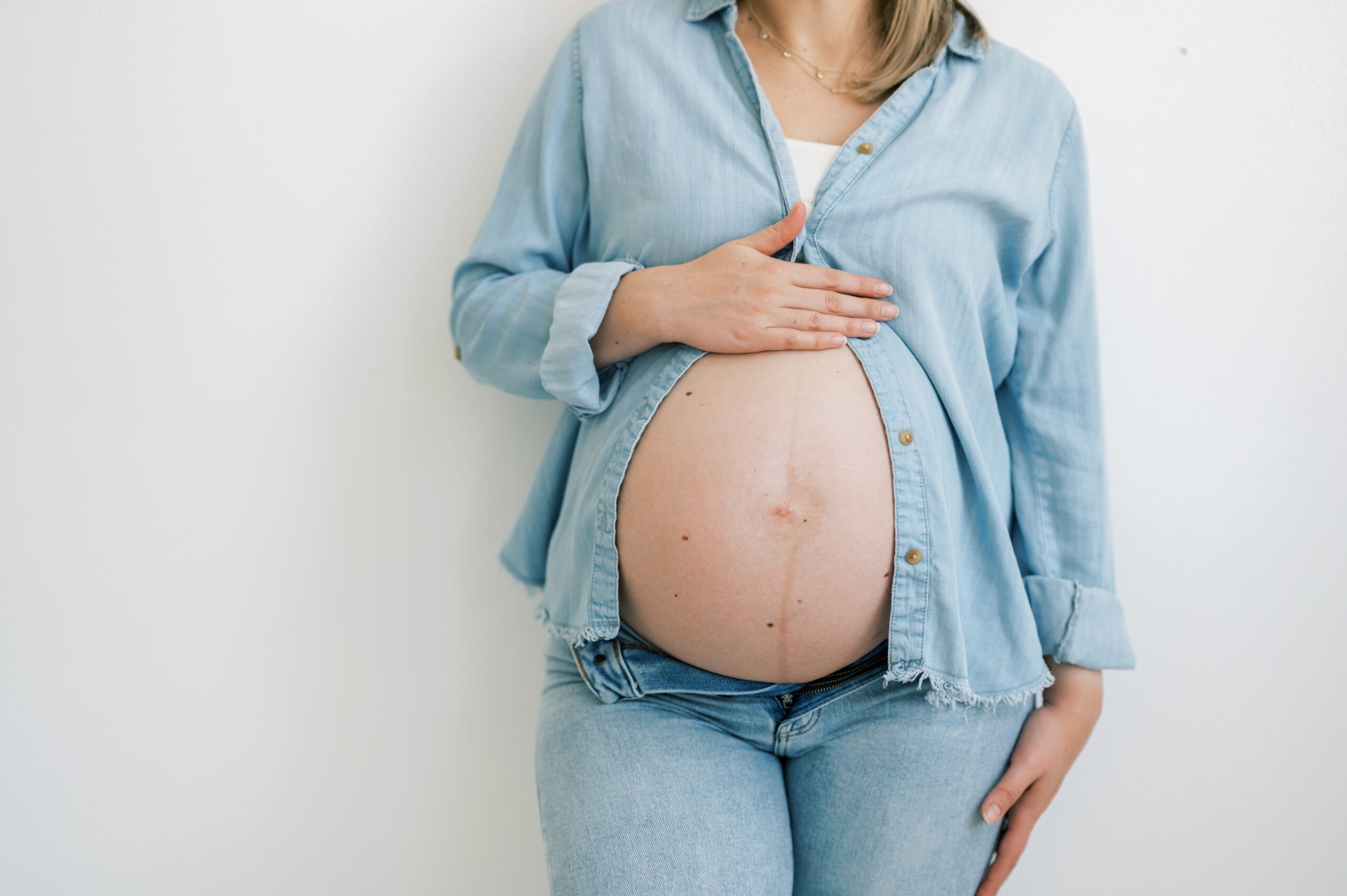 mom holds baby bump during studio maternity session in fort worth