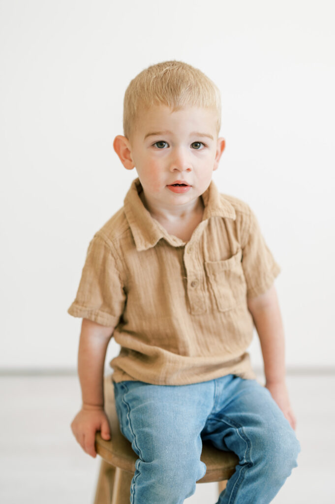 boy sits on stool in studio space