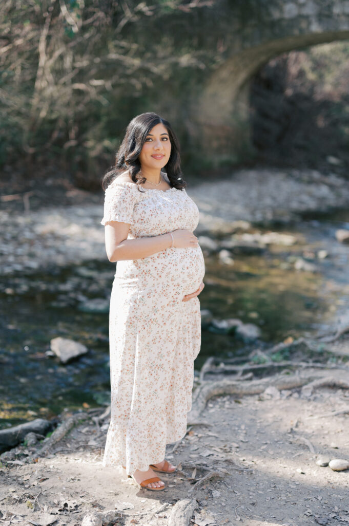 mom to be holds bump creekside in prather park