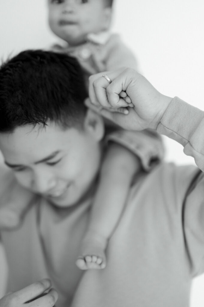 dad holds little boy's hands