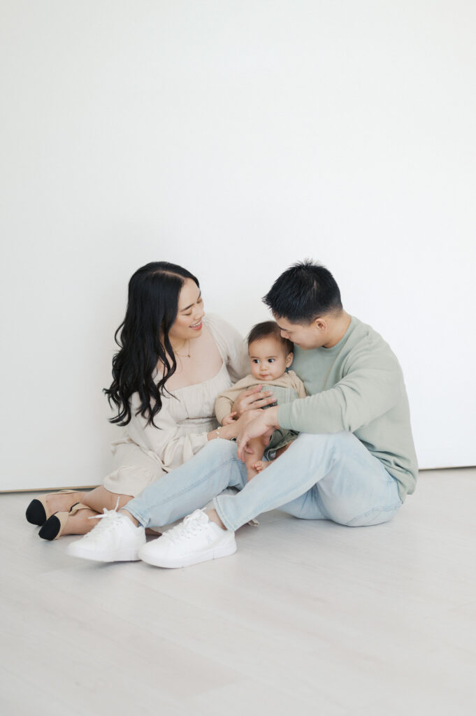 family sits in studio cuddling little boy