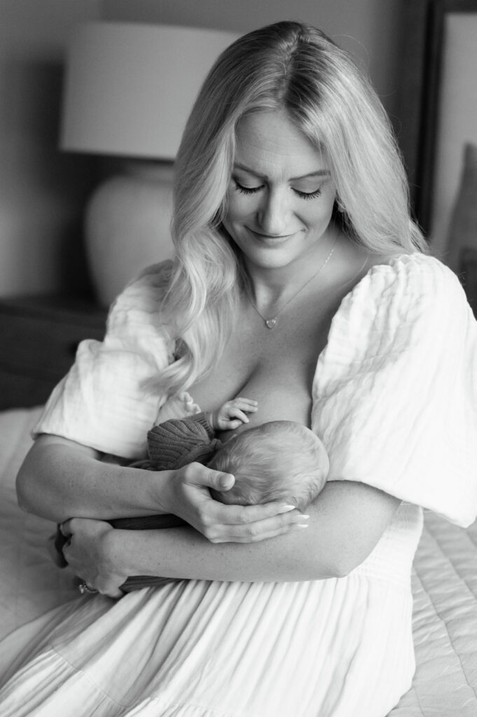 mom smiles down at baby while nursing in bedroom