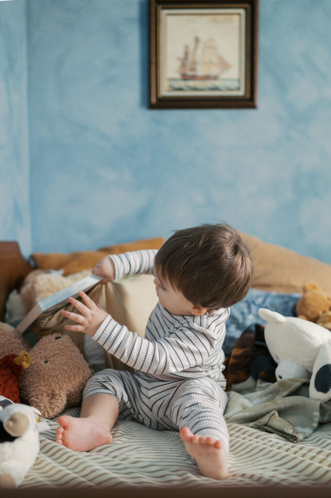 little boy gathers his toys together during family photos