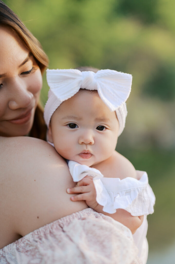 mom snuggles baby girl during family photos in fort worth