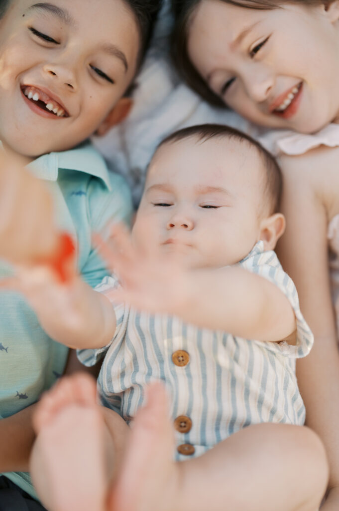 kids cuddle on blanket during family photos