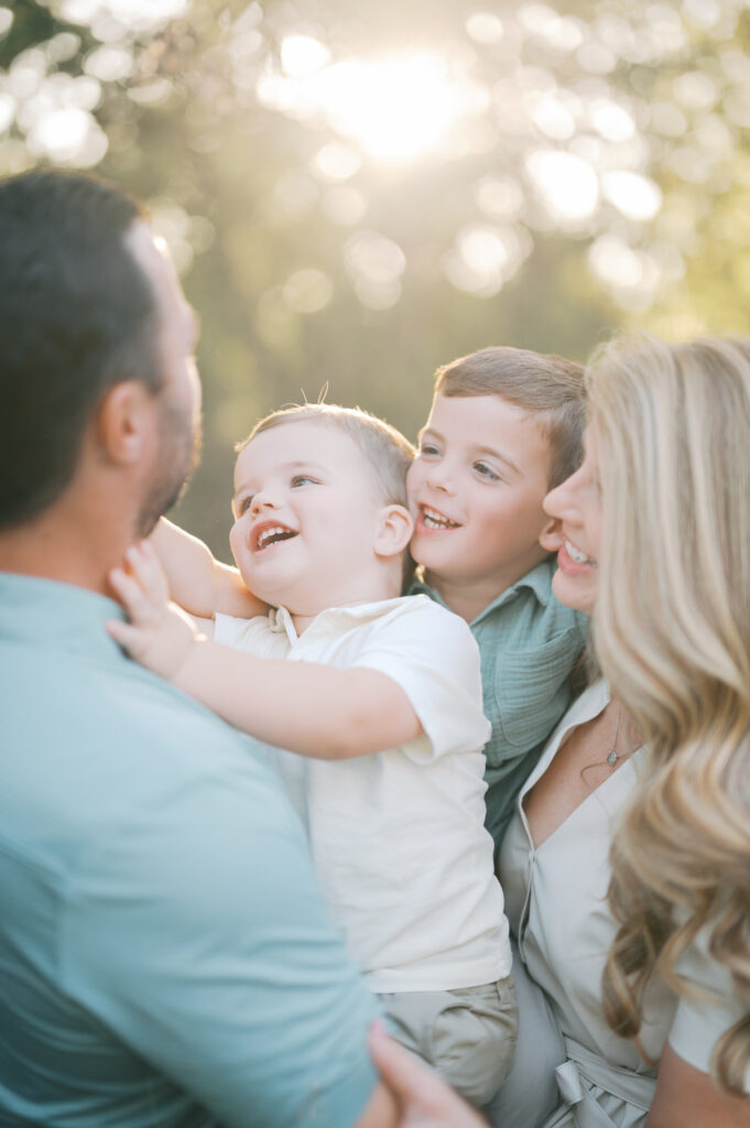 family of four gathers close with their boys during family photography session