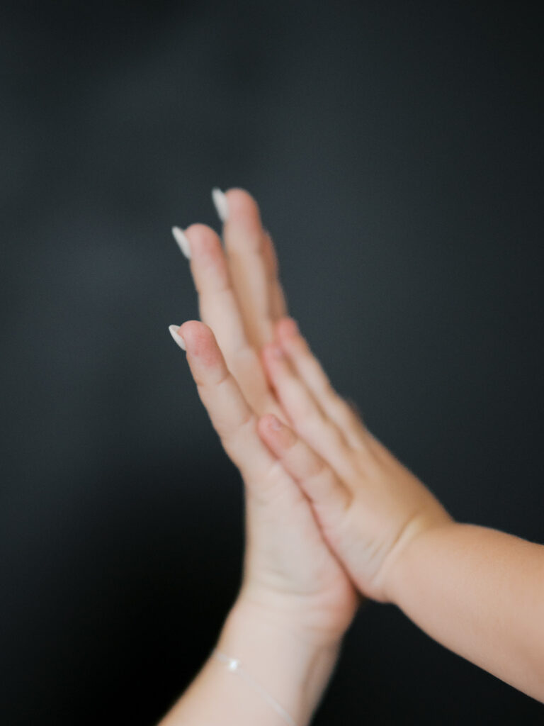 detail image of mom and young kid's hand next to each other
