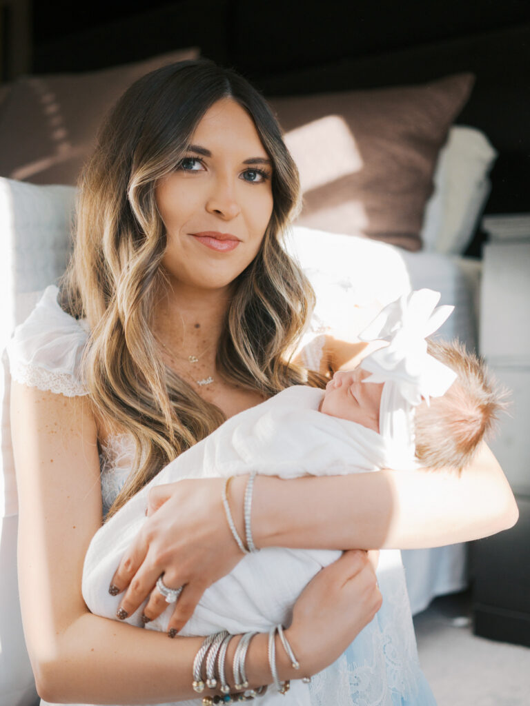 mom sits with baby with light coming through windows