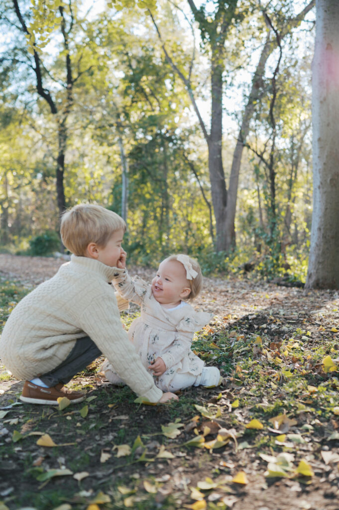 young kids play in the leaves at the fort worth botanic garden