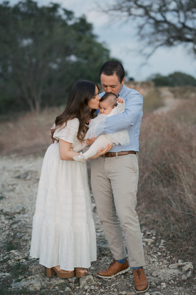 mom, dad, and baby snuggle close during fort worth fall family photos