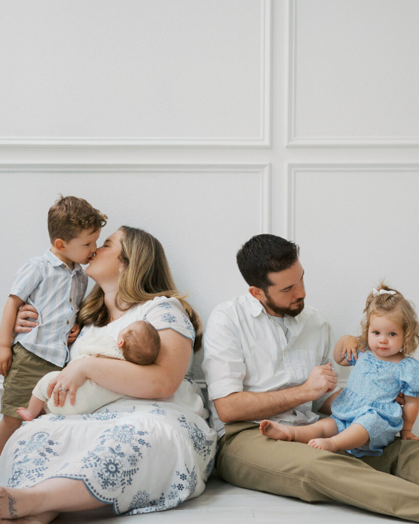 family of five gathers in studio during newborn photos
