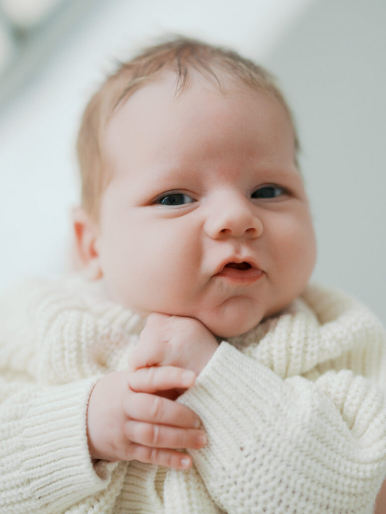 newborn baby looks at camera during studio newborn session at the lumen room