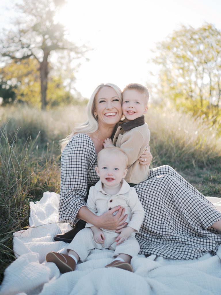 mom and two young kids smile during fall family photos