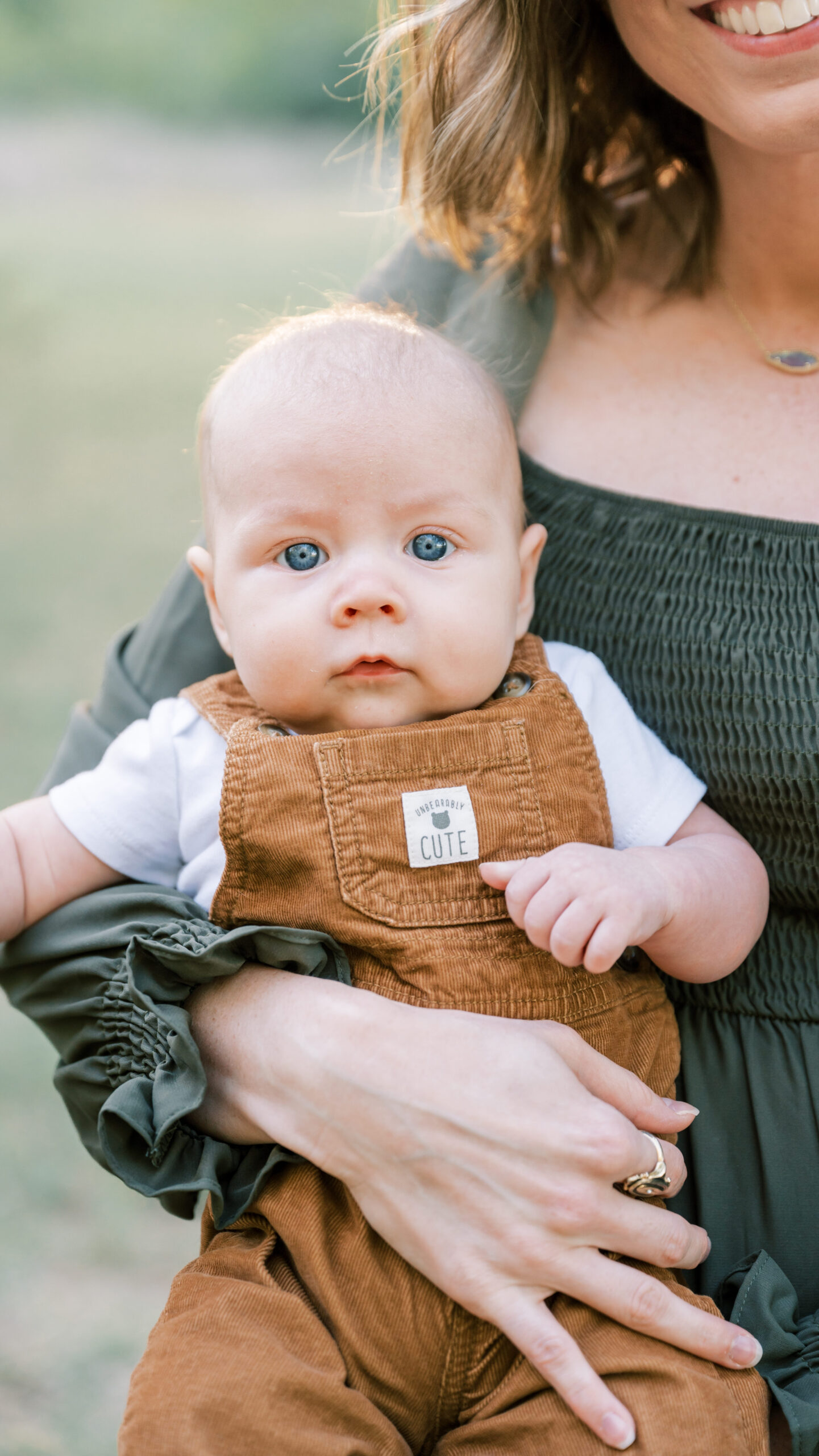 baby stares at the camera while mom holds him