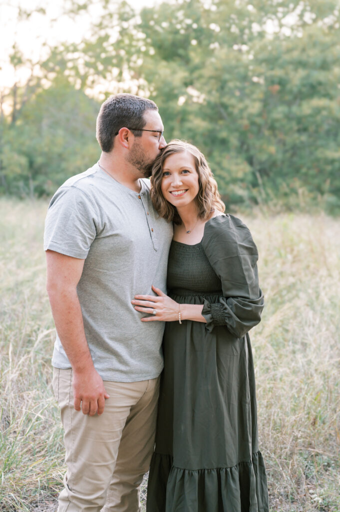dad kisses mom's head while mom smiles