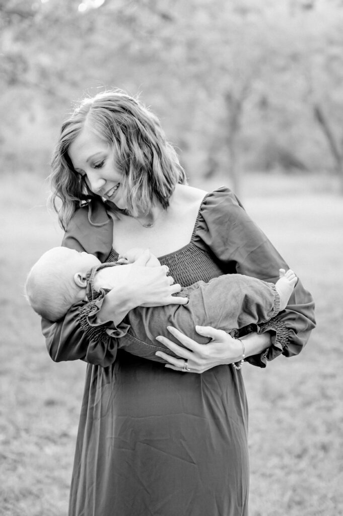 mom rocks baby in wooded area