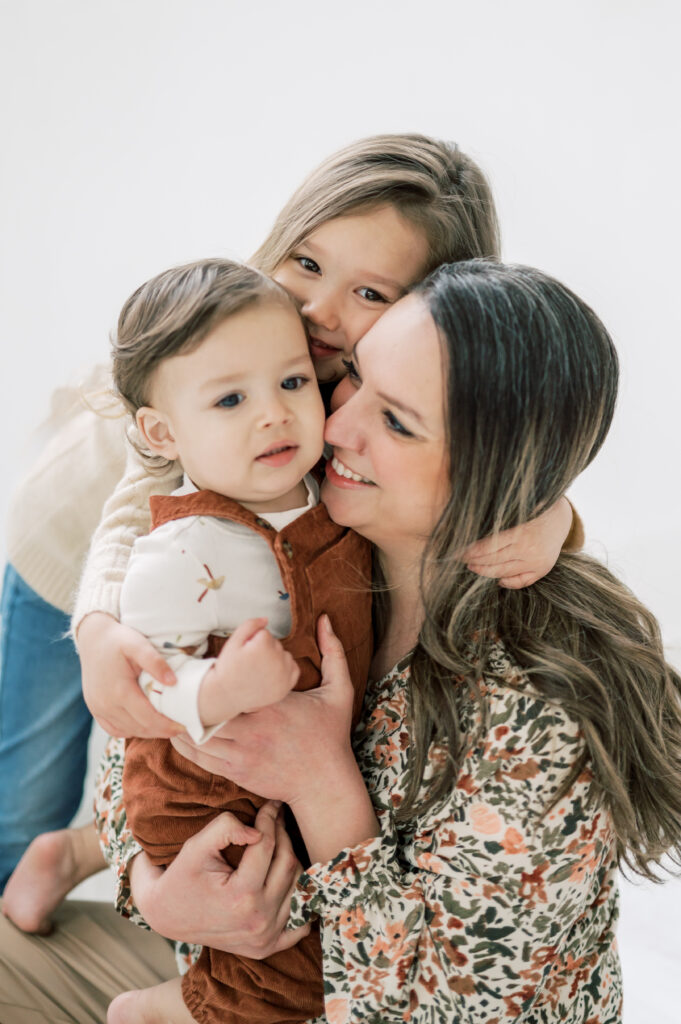 mom hugs two kids close during motherhood mini sessions in fort worth