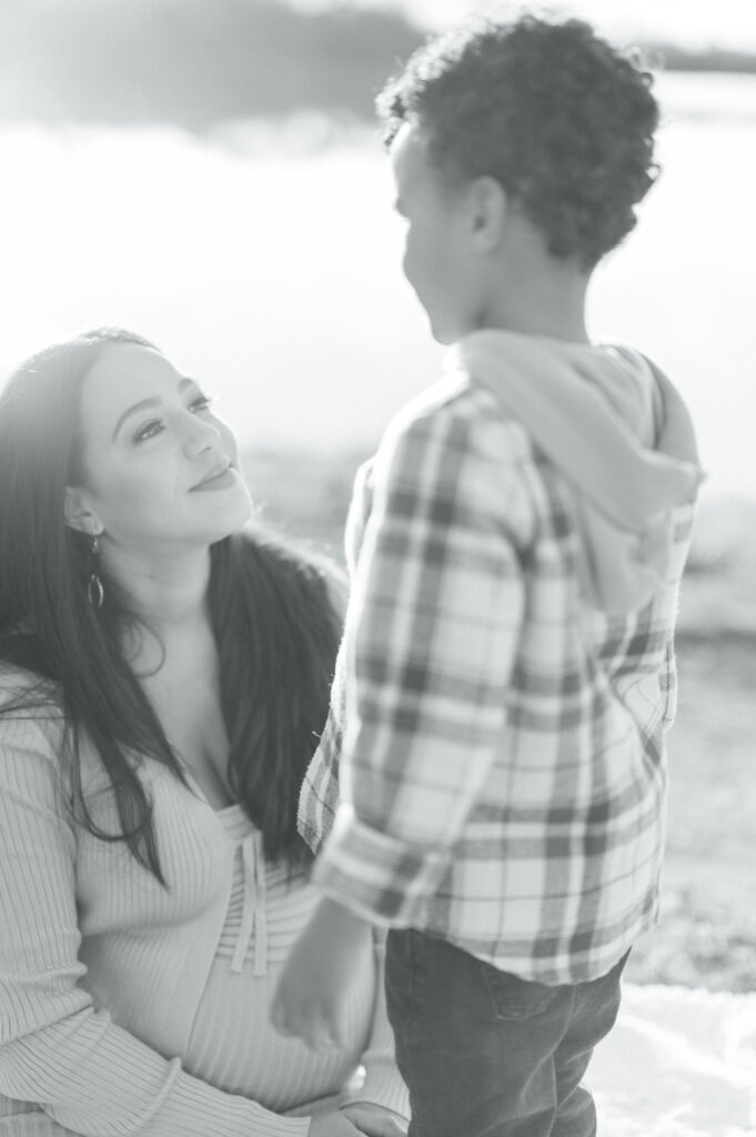 mom looks up at little boy with sun shining on them