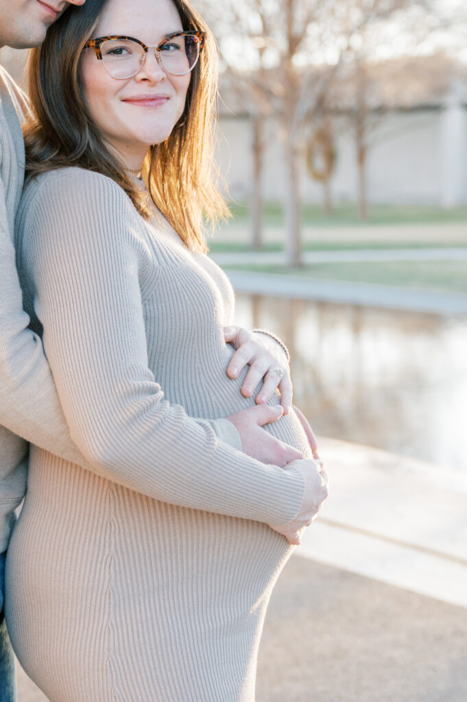 expecting mom gives a soft smile while she looks at the camera