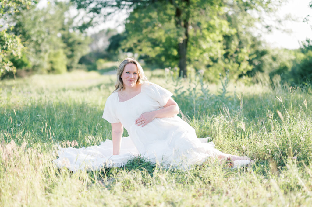 mom poses for maternity session photos in a field in Fort Worth