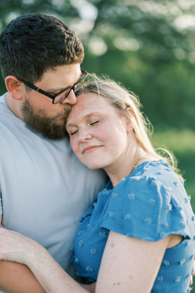 mom and dad snuggle close during family photo session 