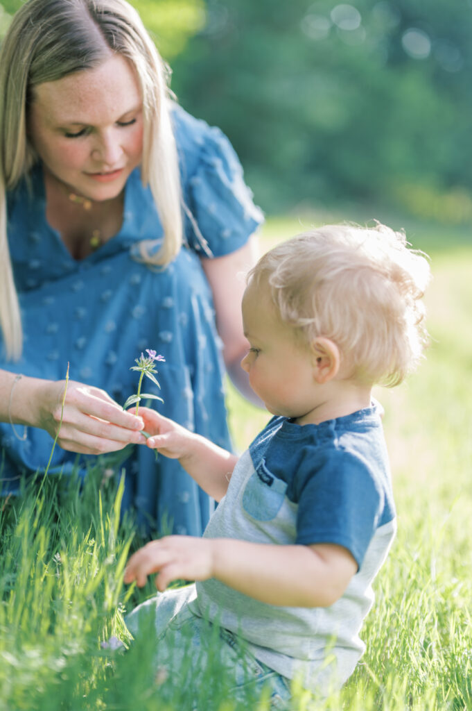 mom picks wildflower in an outdoor field