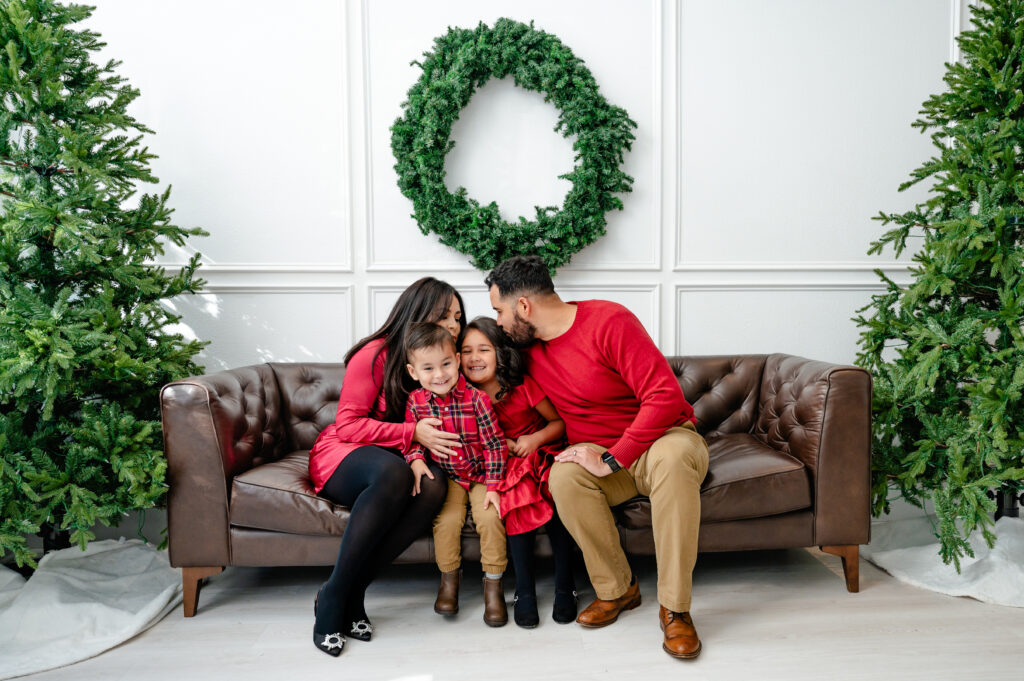 family sits on couch for photo during fort worth photography christmas session