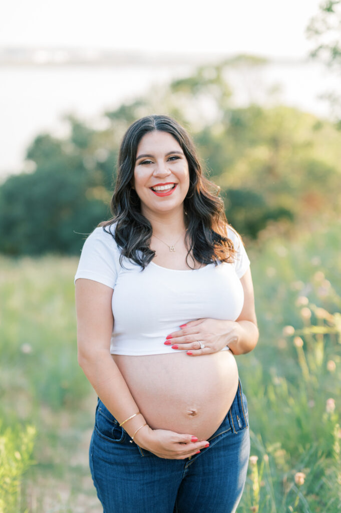 mom embraces baby bump and smiles