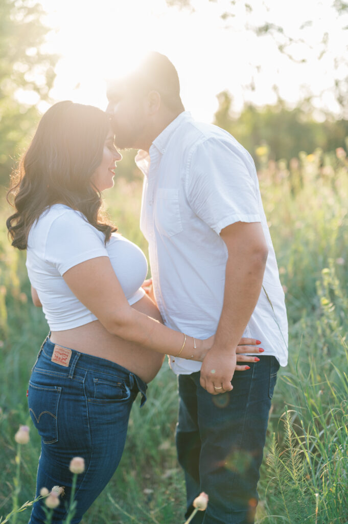 mom and dad kiss in sunlight