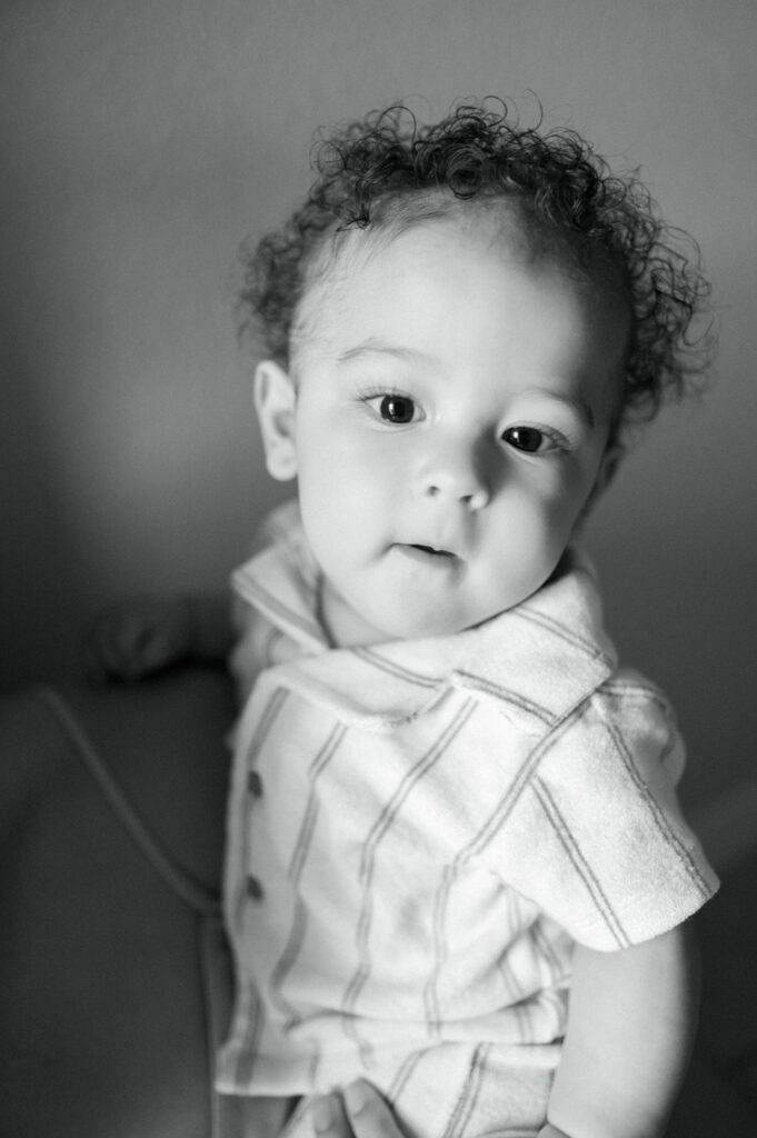 6 month old boy looks back at camera