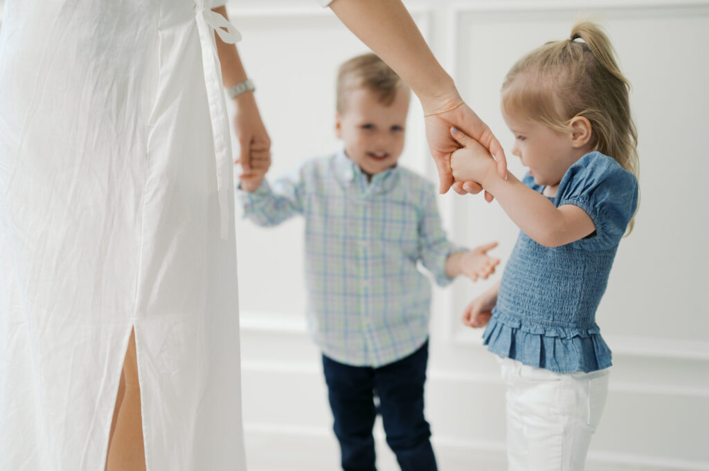 detail shot of mom holding hands of twins during motherhood photo session