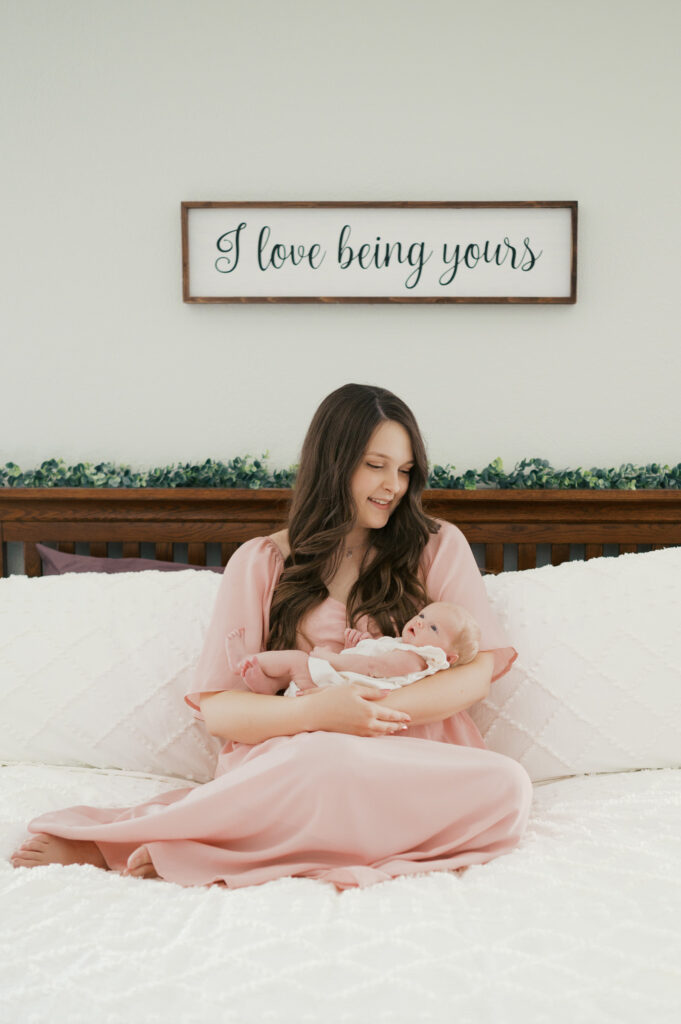 mom looks adoringly at newborn baby