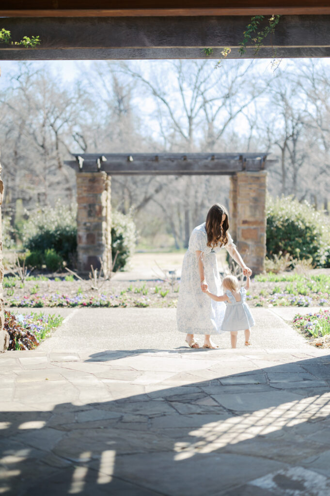 mom dances with daughter in the sunlight