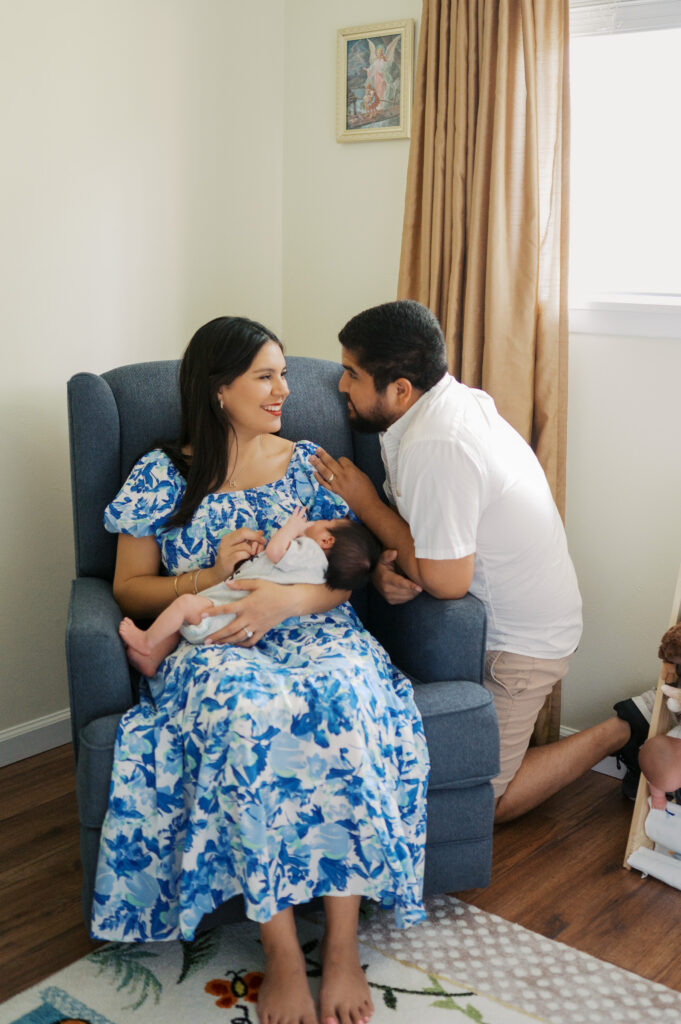 at home lifestyle newborn photos, dad looks adoringly at mom