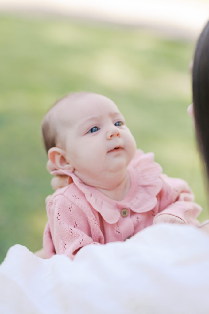 newborn baby looks up at mom with a small smile