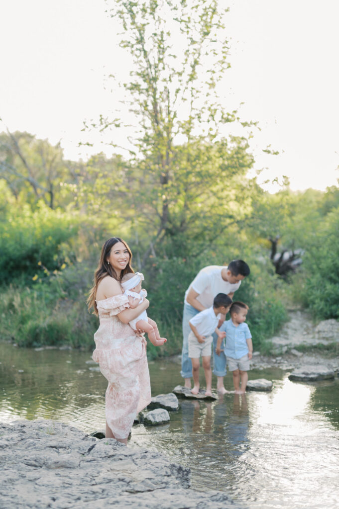 family plays in creek and mom looks back at camera