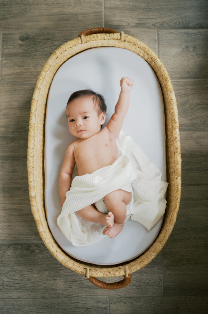 newborn baby lies in basket during newborn photos, 2 months old