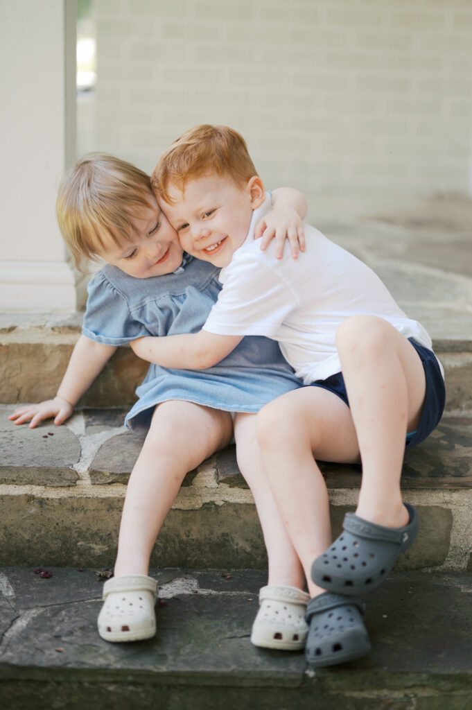 siblings hugging each other on front porch