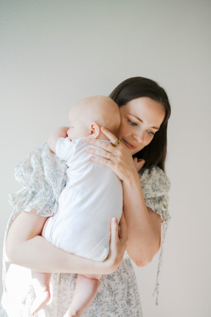 mom holds baby during newborn photos