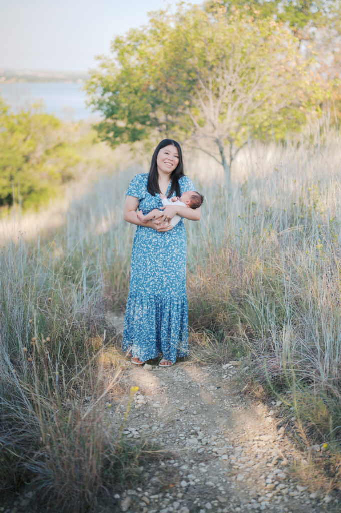 mom walks newborn baby outside during newborn photos in north fort worth