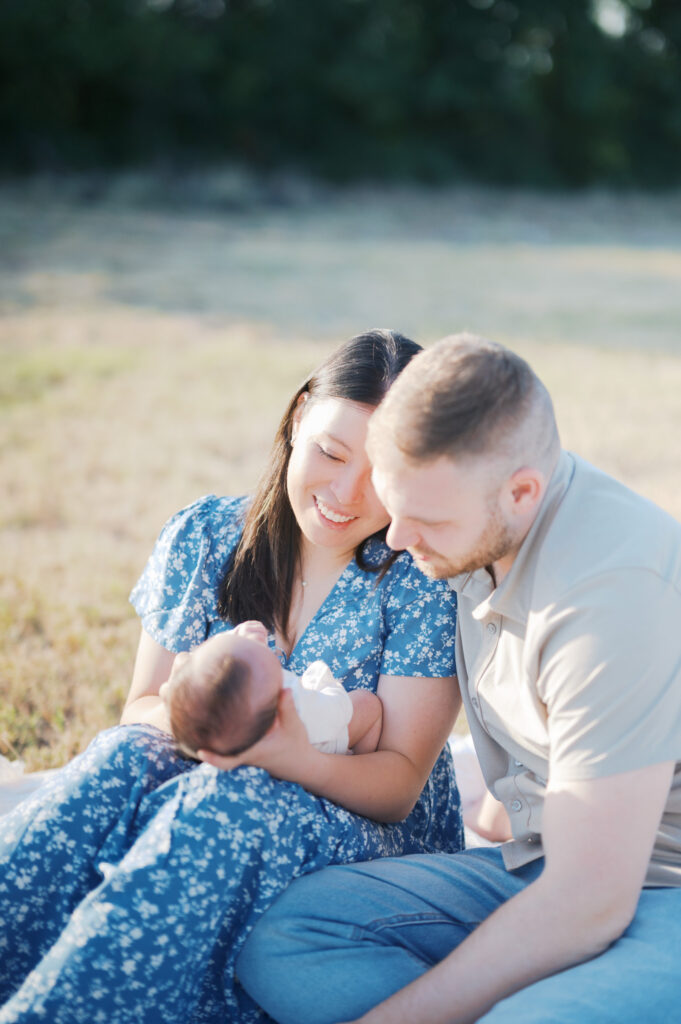 new mom and dad looks adoringly at their baby boy outdoors in fort worth 