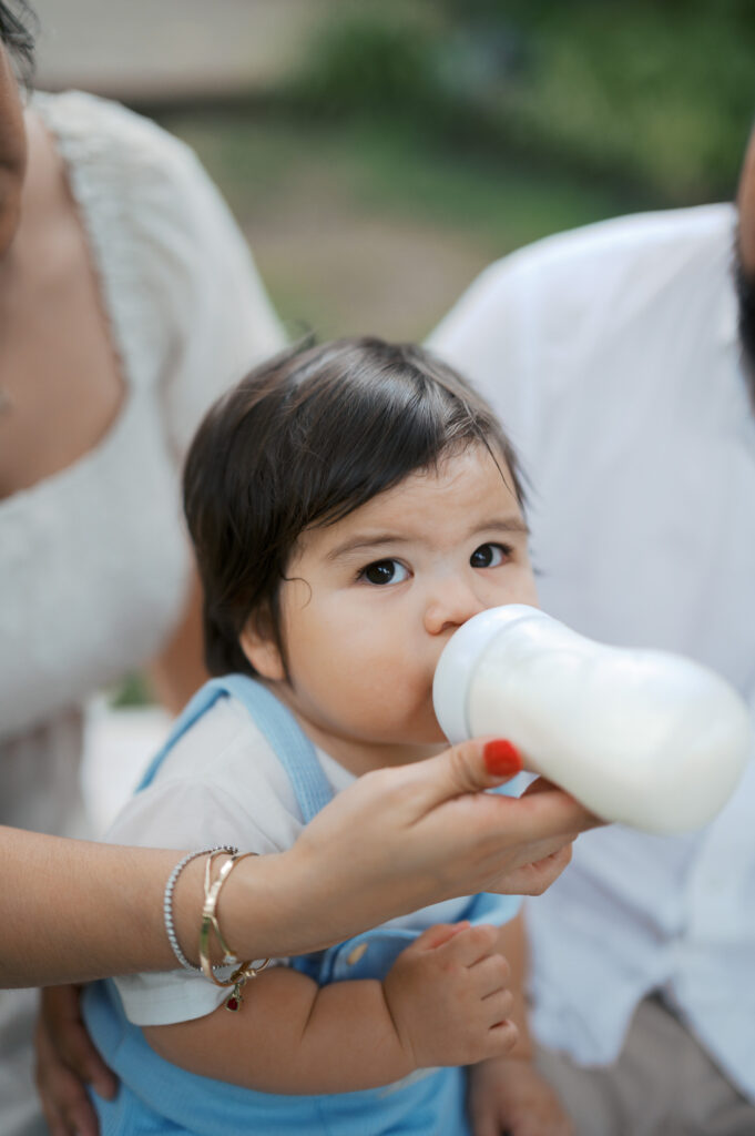 one year old drinks milk during cake smash photos