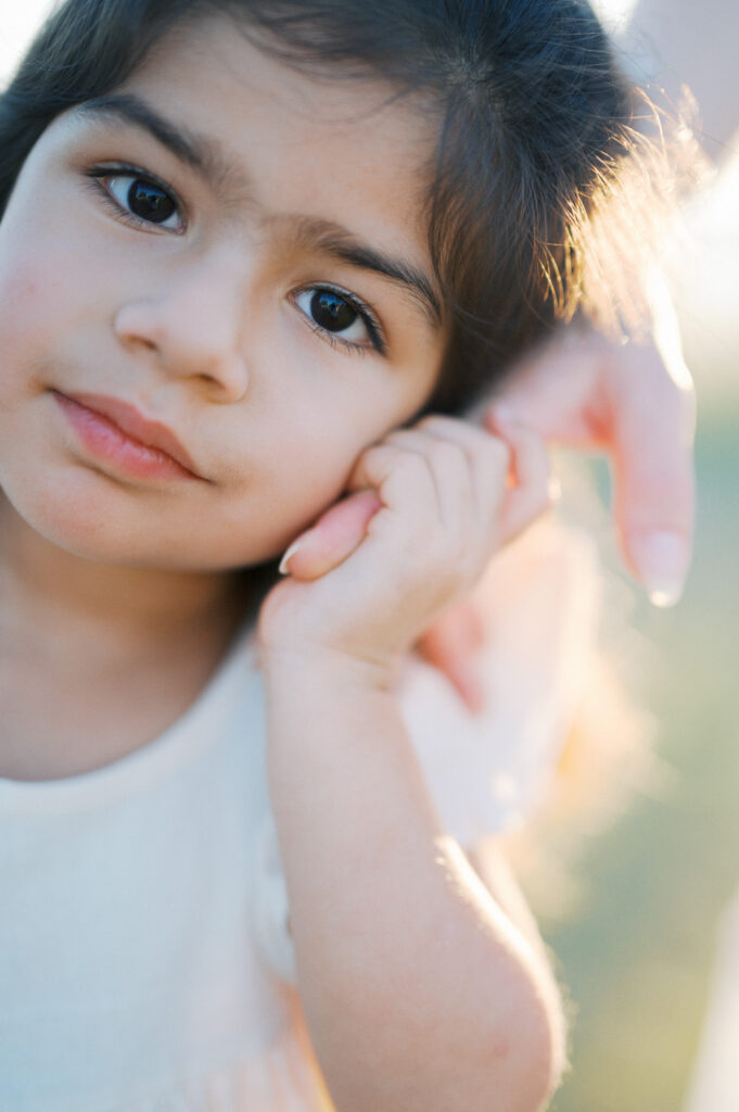 child looks at camera during outdoor family maternity photos