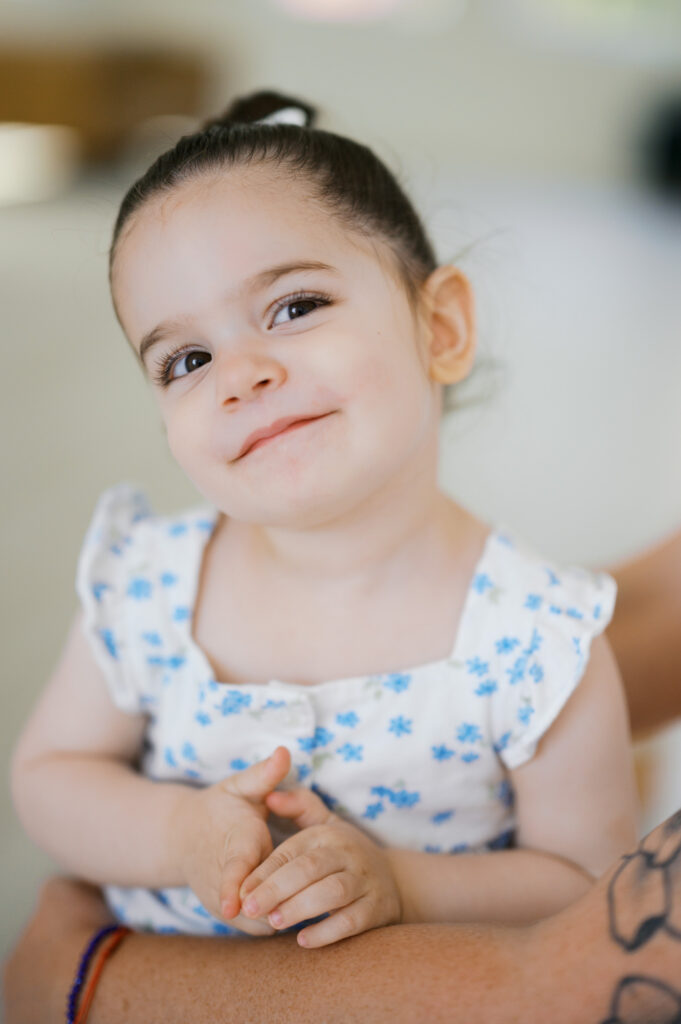 little girl grins at camera during family photos in fort worth