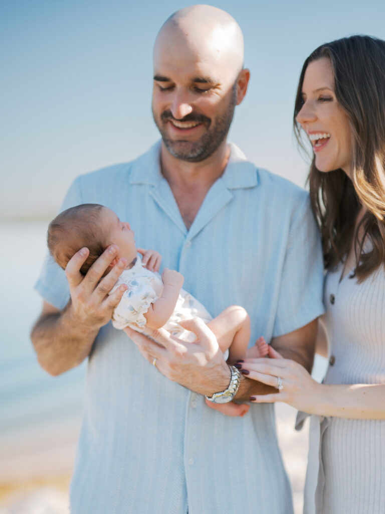 parents smile at newborn baby outside during lifestyle newborn photos, lakeside in arlington