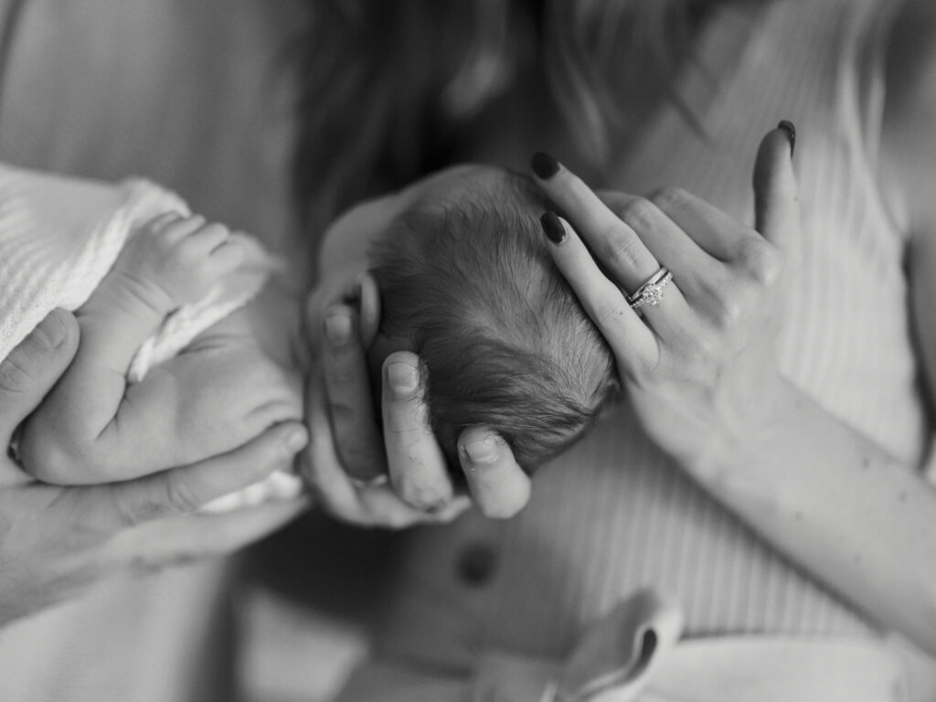 detail photo of parents holding newborn baby during in home lifestyle newborn photos in fort worth